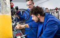 Ausbilder und Teilnehmer an Hydraulikstand